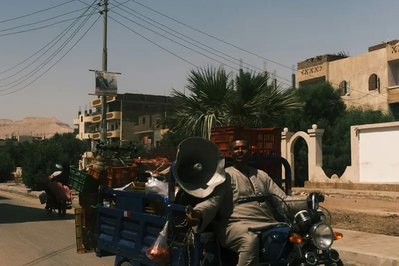 A three-wheeled cargo motorcycle making a delivery